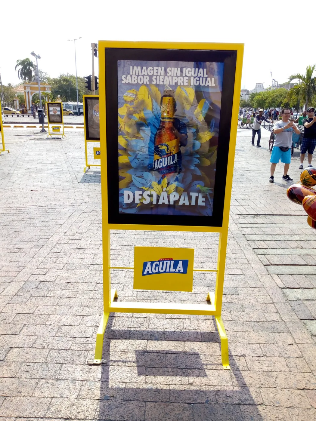 Mobiliario promocional amarillo de Águila con marco publicitario, gráfica de producto y estructura autoportante para activación exterior