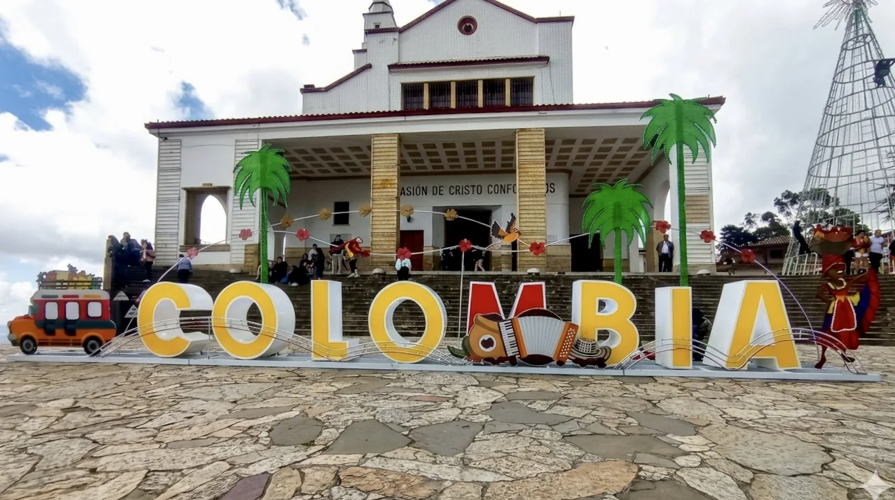 Letras volumétricas de Colombia instaladas en espacio público con elementos culturales, palmeras y figuras decorativas para activación turística