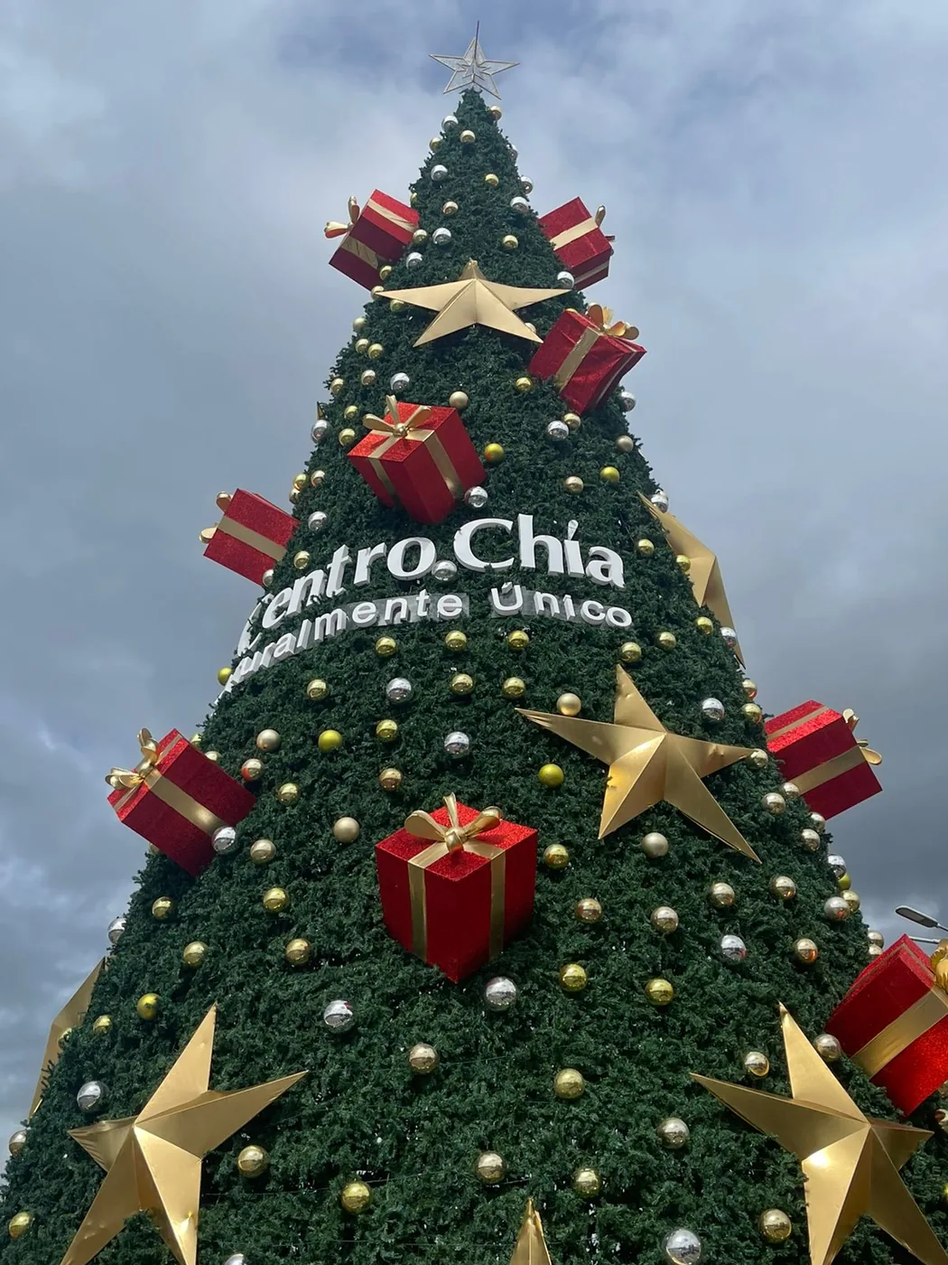 Parte superior de árbol navideño en Centro Chía con decoración de regalos, estrellas e iluminación ornamental