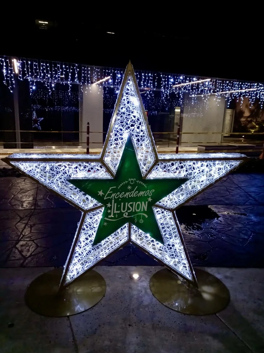 Estructura decorativa navideña en forma de estrella con centro verde e iluminación perimetral para montaje de temporada