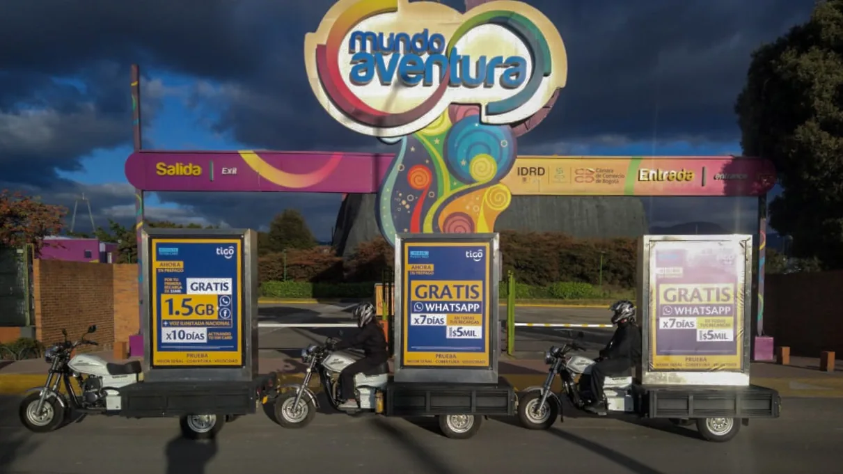 Caravana de motos valla publicitarias de tigo frente a mundo aventura