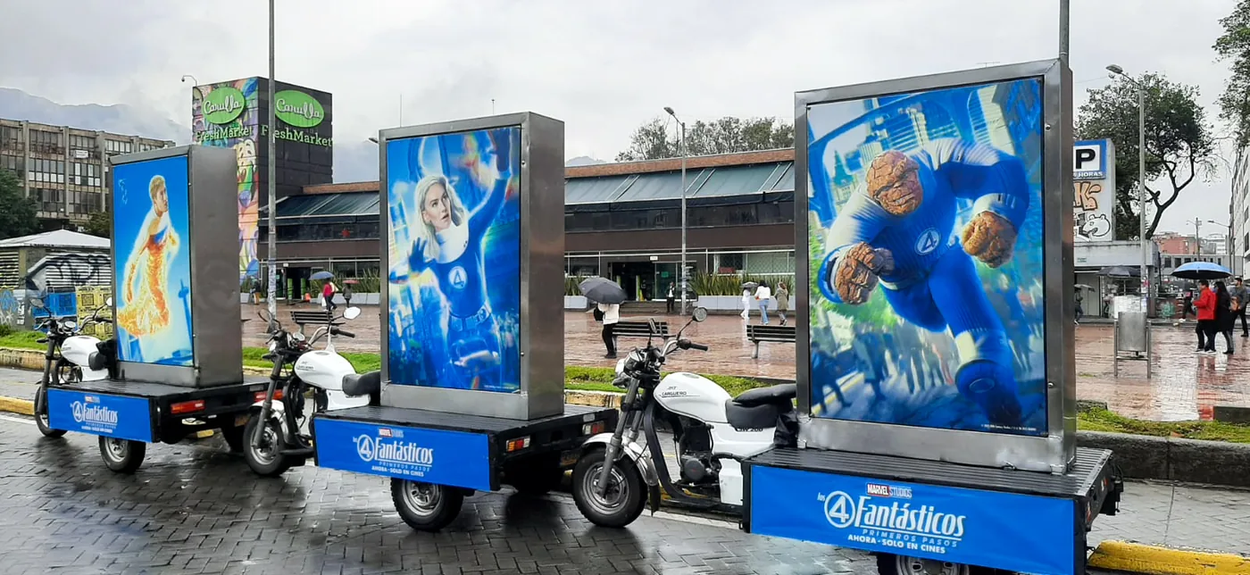 Motos valla publicitarias con avisos de  la pelicula de los 4 fantásticos frente al carulla de la 85