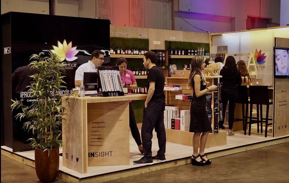 Stand gastronómico o de experiencia de marca en ambiente interior, con barra, mobiliario alto y atención al público