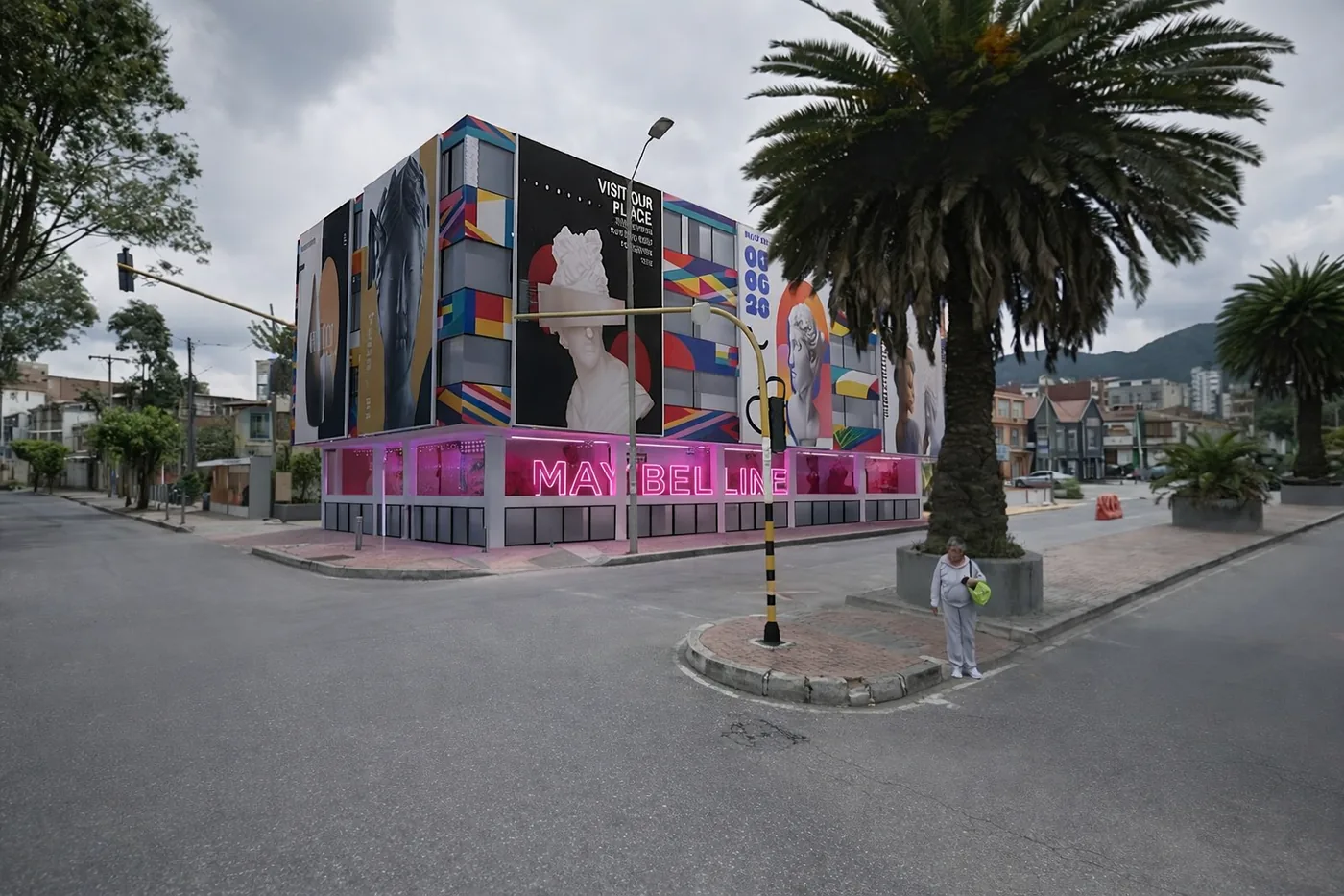 Intervención exterior de local o edificio comercial con branding en tonos rosados y presencia de marca en esquina urbana