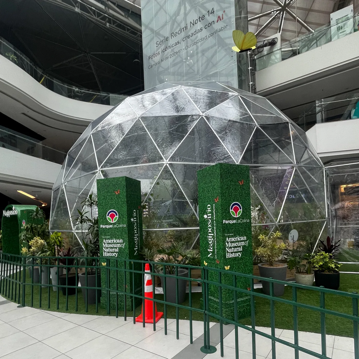 Instalación escenográfica interactiva en centro comercial con estructura curva de gran formato, iluminación LED perimetral y zona delimitada para experiencia de marca