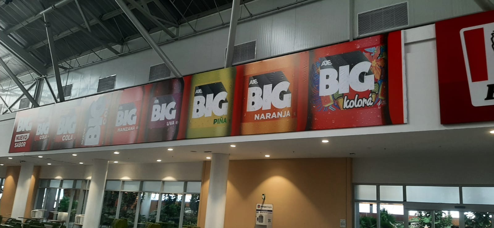 Zona de experiencia de marca BIG con juegos interactivos y piso brandeado en centro comercial